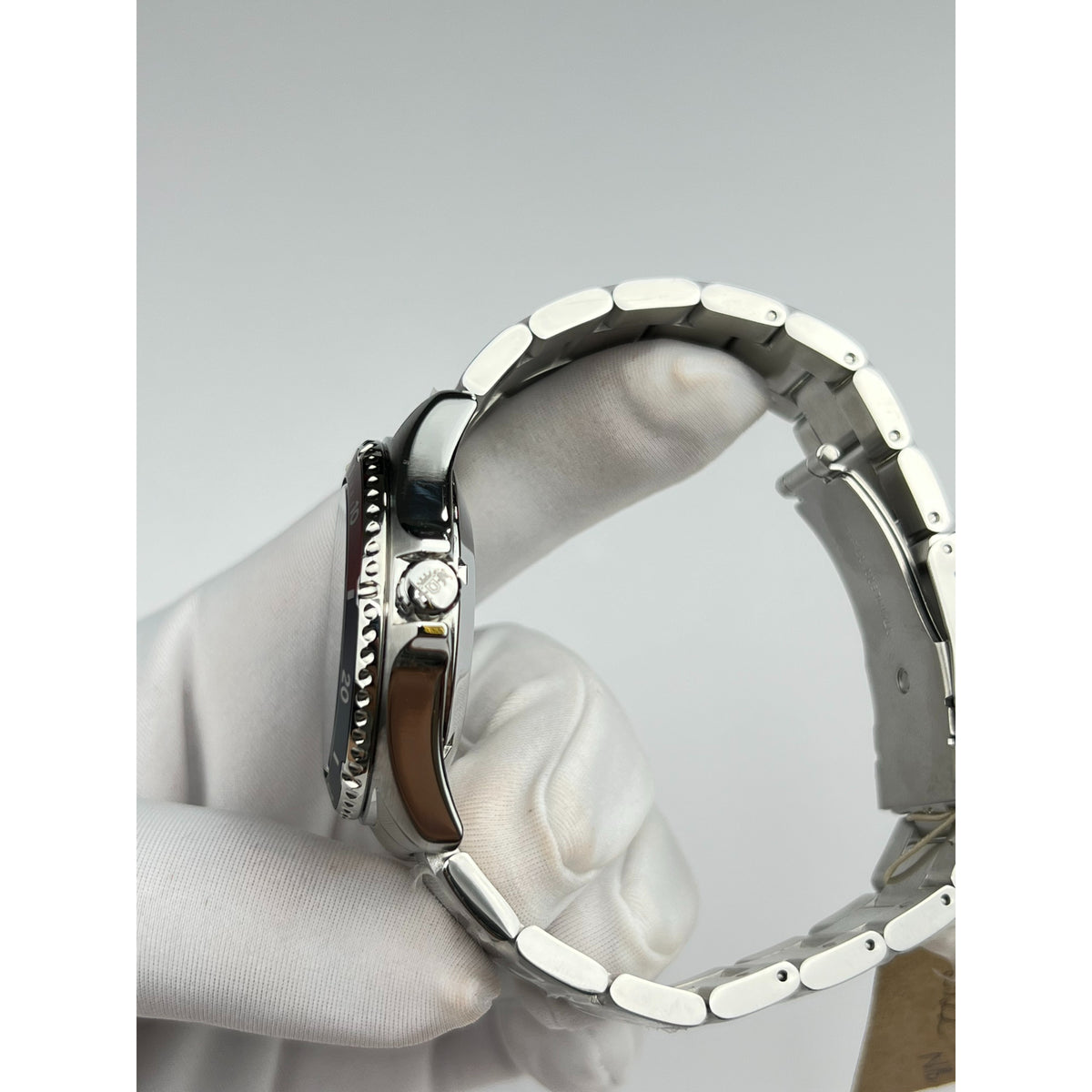 Men's stainless automatic diver watch side view with crown and silver steel bracelet links