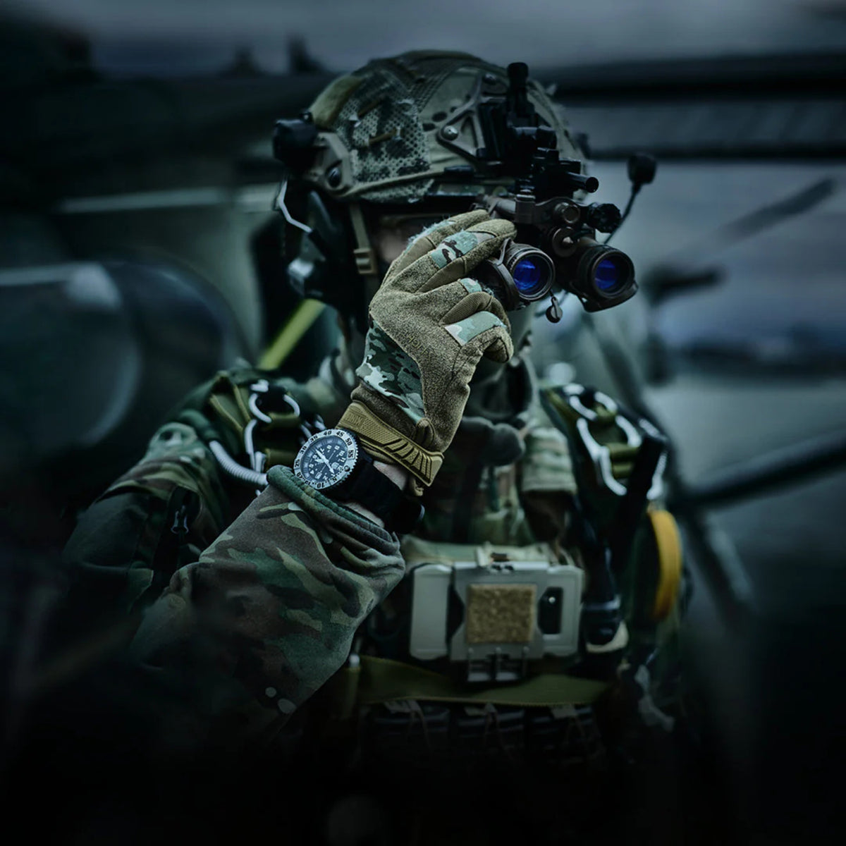 Tactical soldier wearing a Luminox military watch using night vision goggles