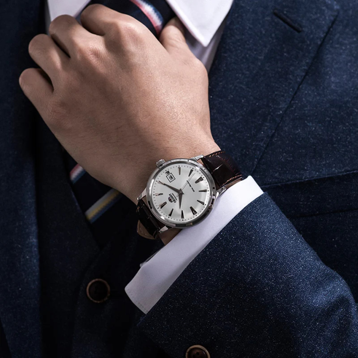 Men's wristwatch on arm: white dial with date window and black leather strap
