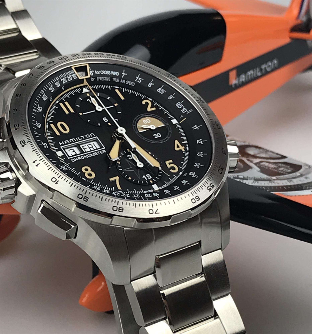 Men's steel chronograph watch close-up, black dial with gold hands and subdials, angled