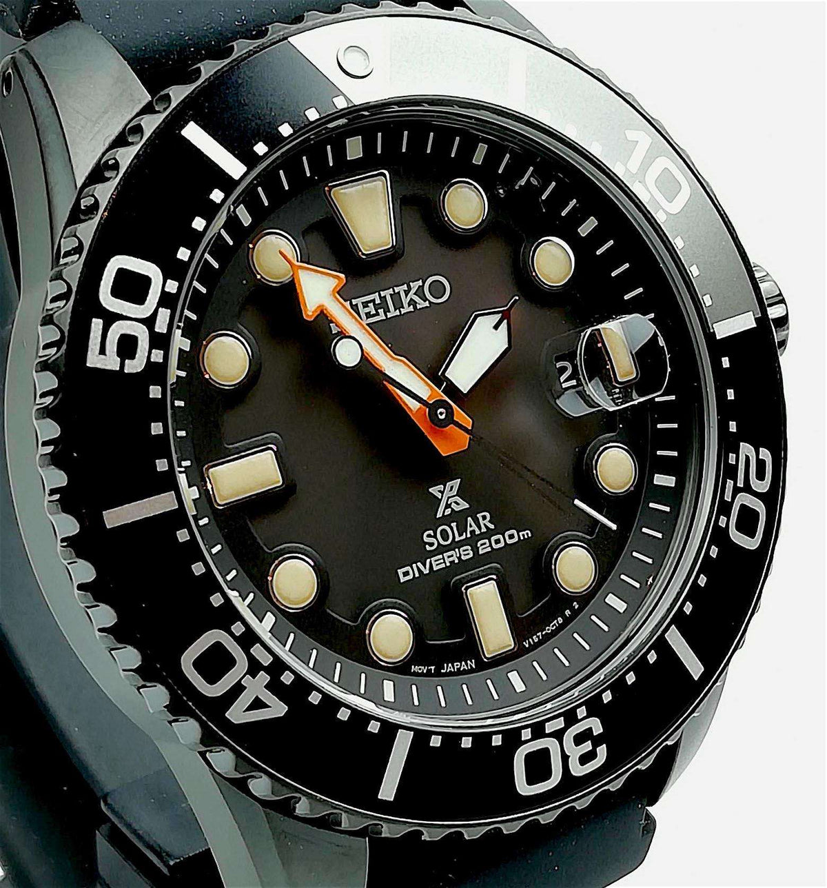 Black dial solar diver's watch with orange-accent hands and black rubber strap.