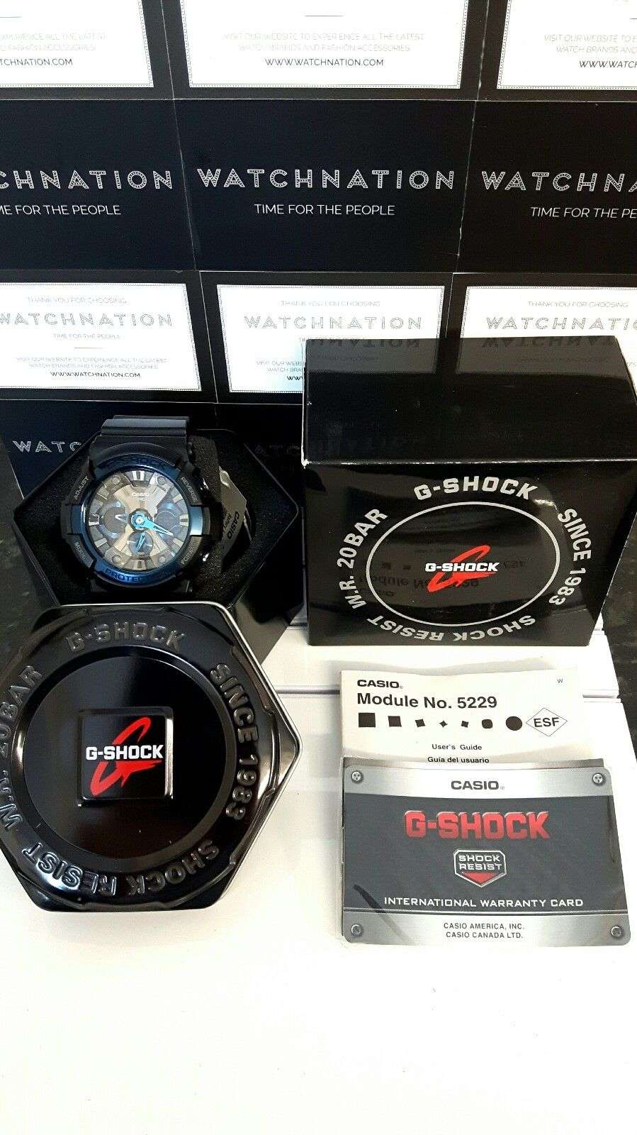 Casio G-Shock watch with retail packaging box, warranty card, and module info