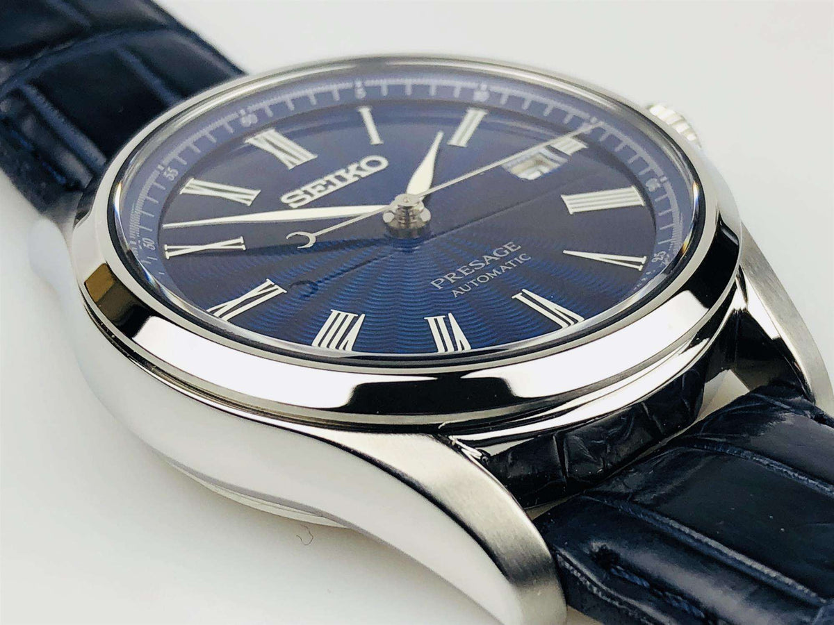 Men's automatic wristwatch top view: blue sunburst dial, Roman numerals, black crocodile leather strap
