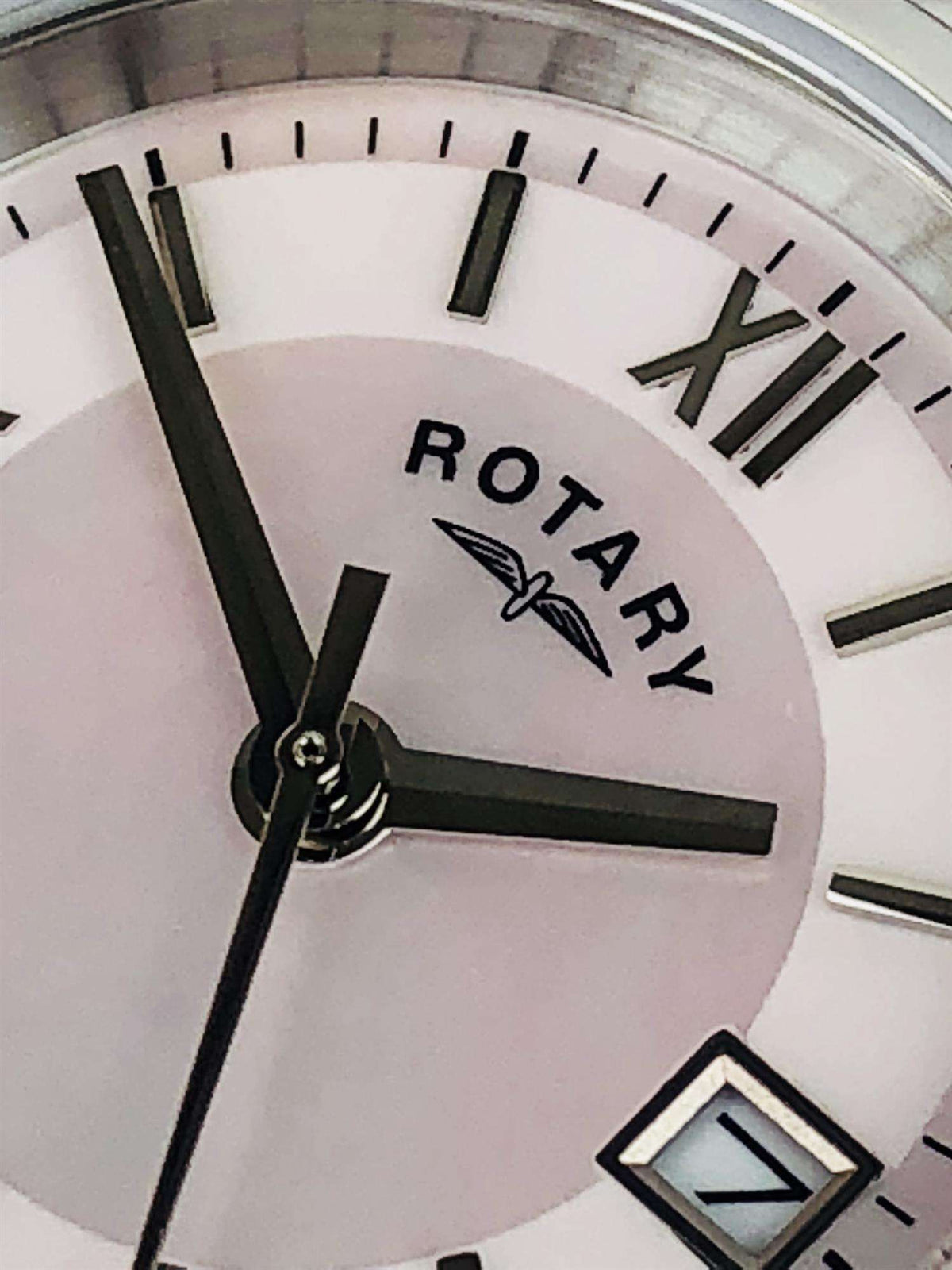 Close-up of mother-of-pearl dial with “ROTARY”, Roman numerals, and black hands