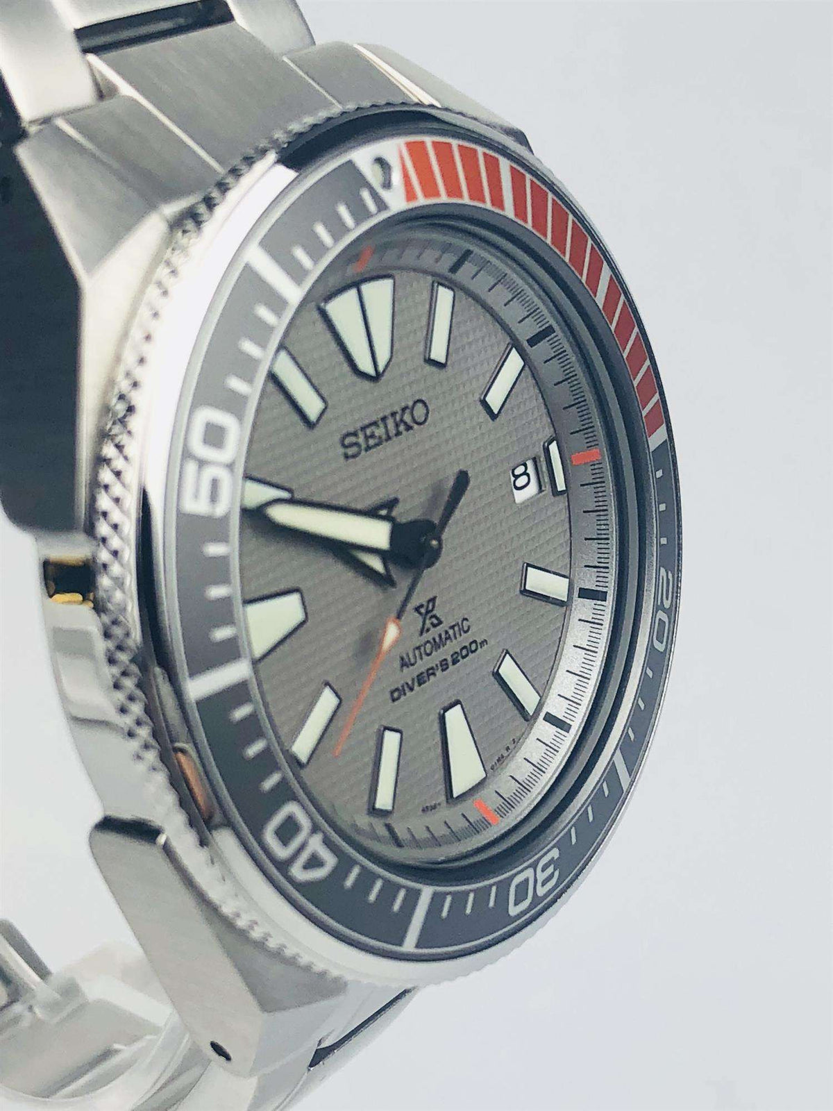 Men's diver watch with grey dial, orange accents, and dark blue bezel