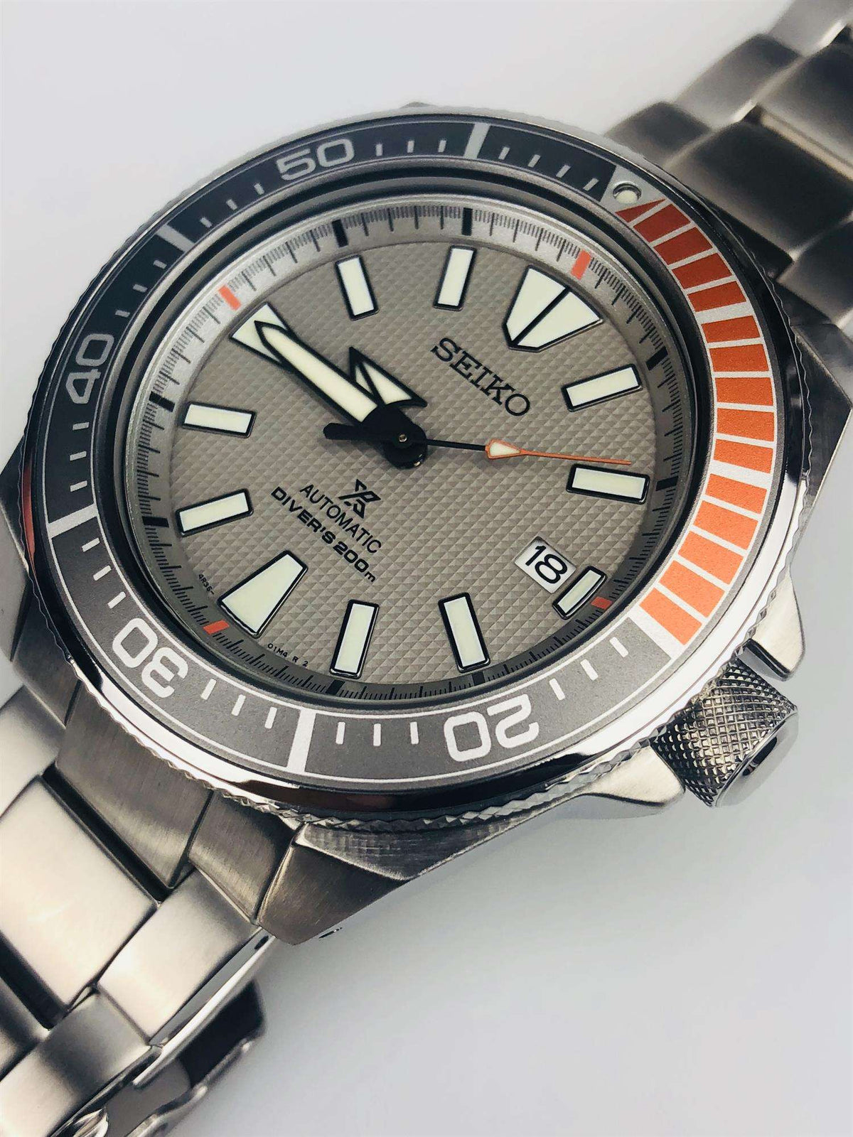 Men's stainless steel diver watch front view with orange bezel stripe and date window