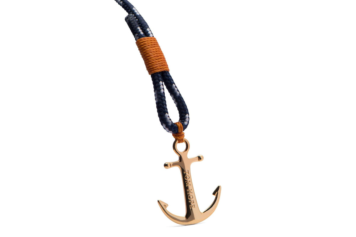 Navy braided cord with orange wrap, small gold-tone anchor charm on ring