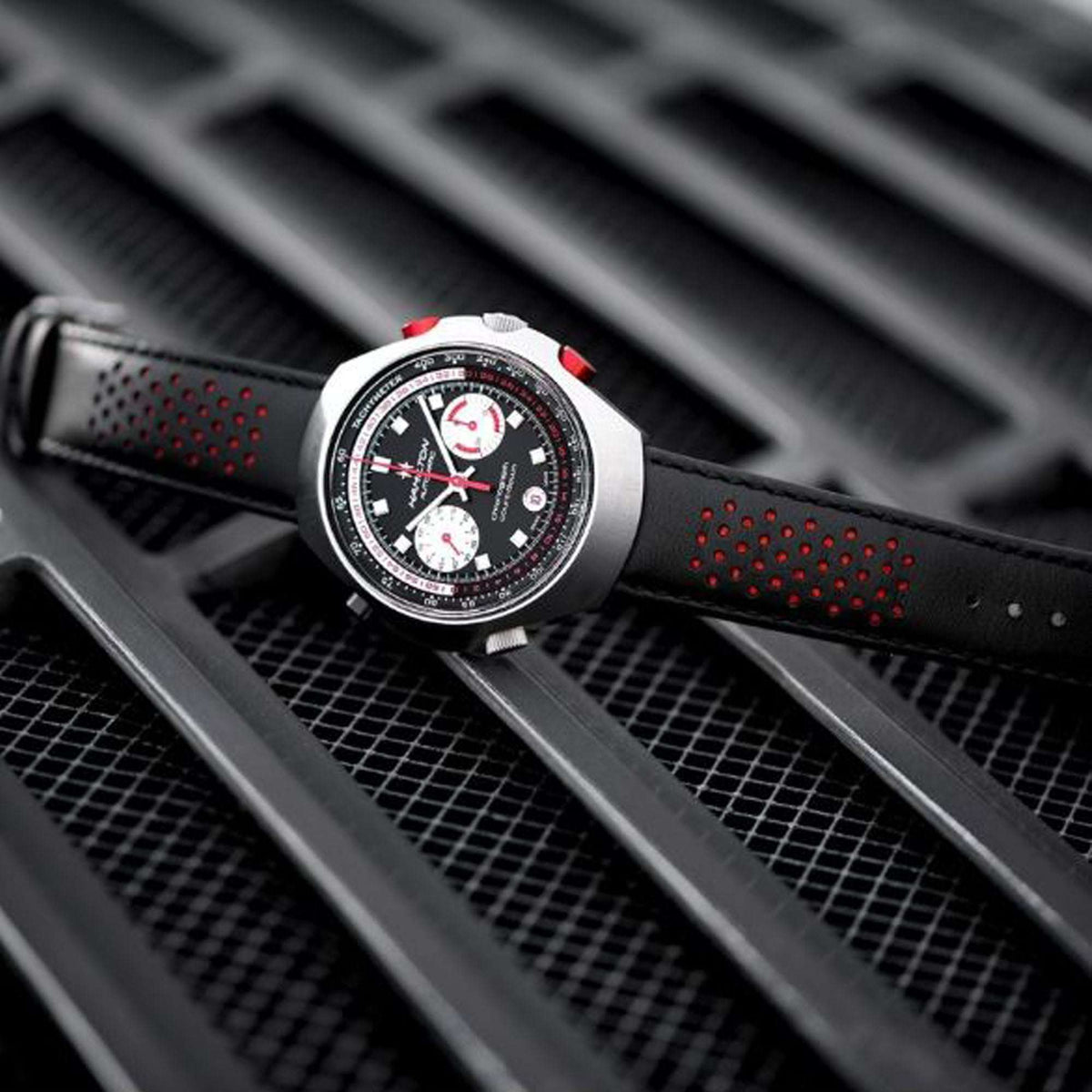 Men’s automatic chronograph watch on dark perforated leather strap with red crown detail