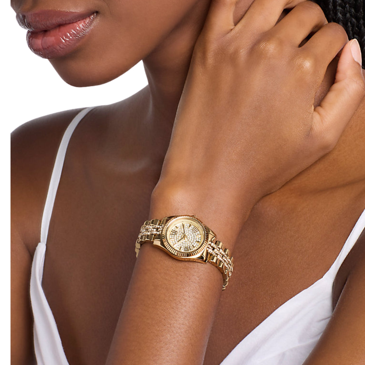 Michael Kors Lexington MK7575 ladies quartz watch worn on a wrist detailing the pavé dial and crystal accented gold tone bracelet