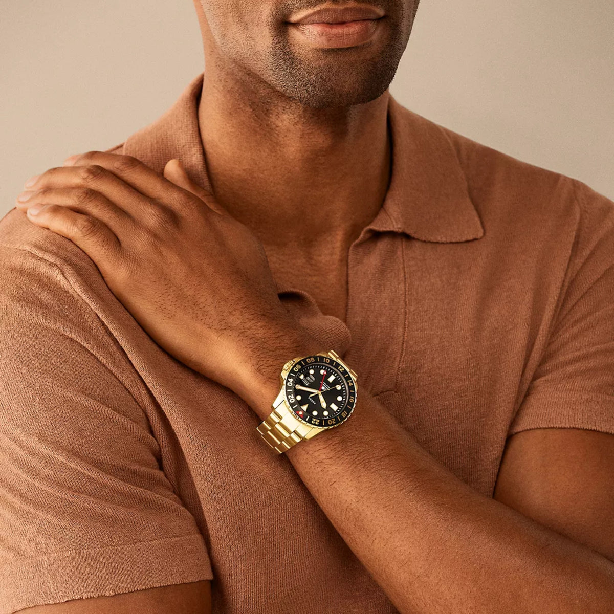 Model wearing the 46mm Fossil Blue GMT FS5990 steel watch paired with a brown polo shirt