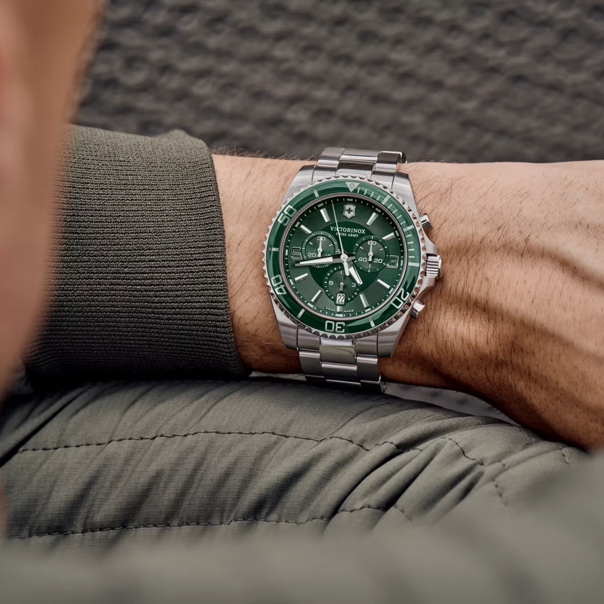 Men's green dial chronograph quartz watch on wrist with stainless steel link bracelet