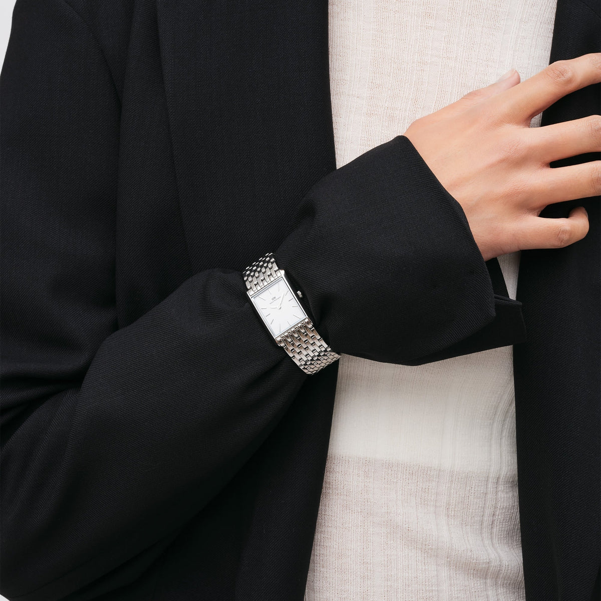 Daniel Wellington watch on wrist with white dial and silver steel link bracelet