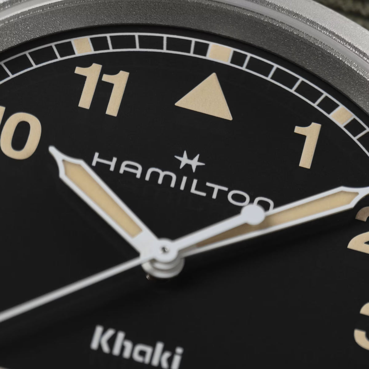 Hamilton Khaki Field H69401930 38mm mens watch close-up detail showcasing black dial with beige Arabic numerals and hands