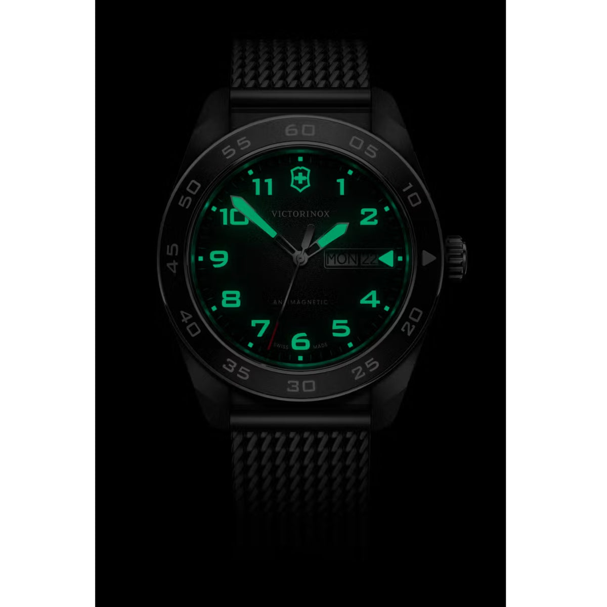 Victorinox Swiss Army quartz watch with black dial and green luminous hands, mesh strap