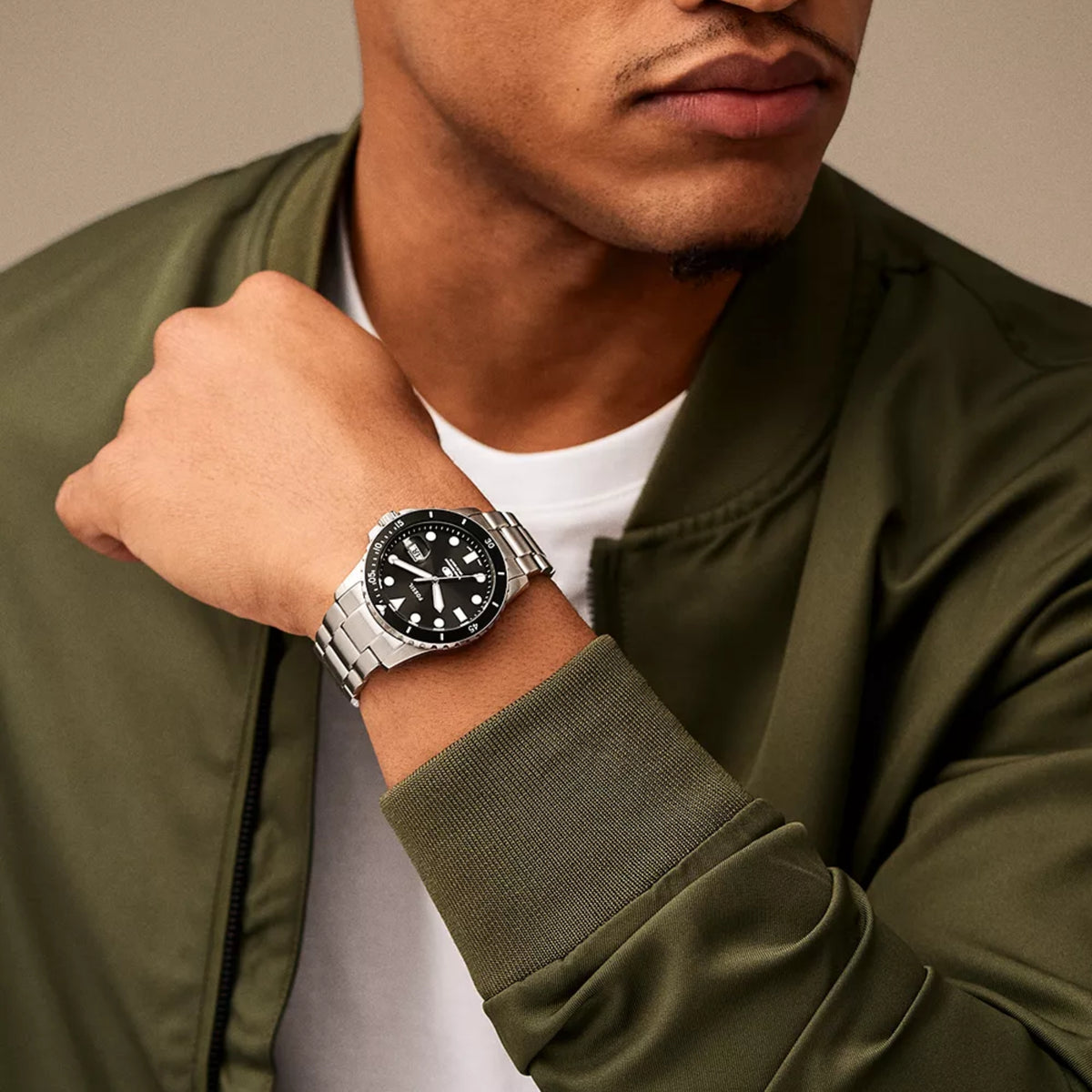 Men’s stainless steel dive watch worn on wrist with black dial and rotating bezel