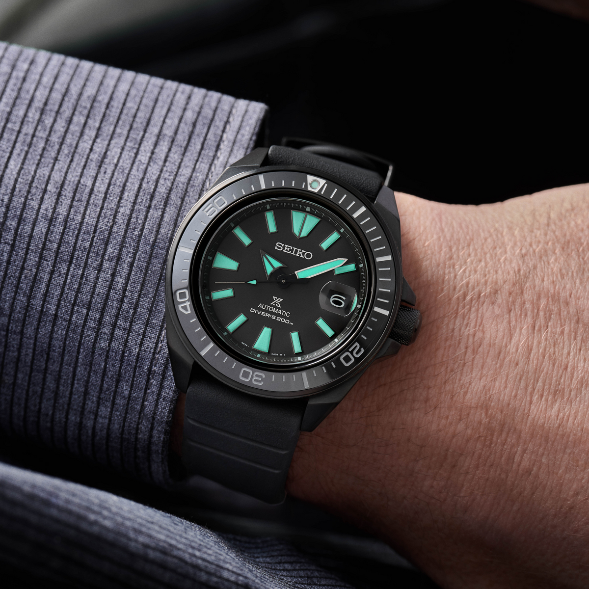 Seiko automatic diver watch on wrist, black case and strap with green indices
