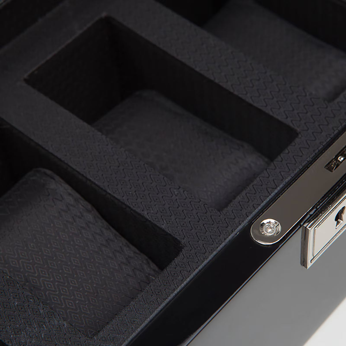 Black foam watch insert with textured grid and metal latch, close-up interior