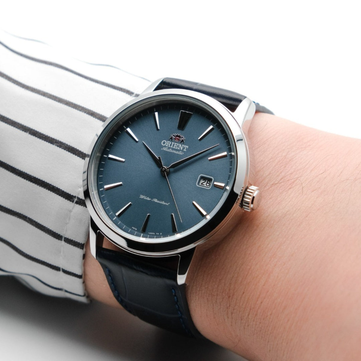 Men's automatic watch with blue dial and black leather strap, on wrist