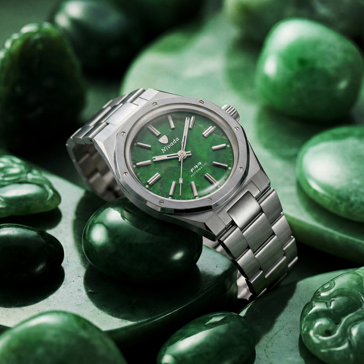 Nivada Grenchen F77 68055A77 angled view on raw green stones showcasing polished steel case and jade dial texture