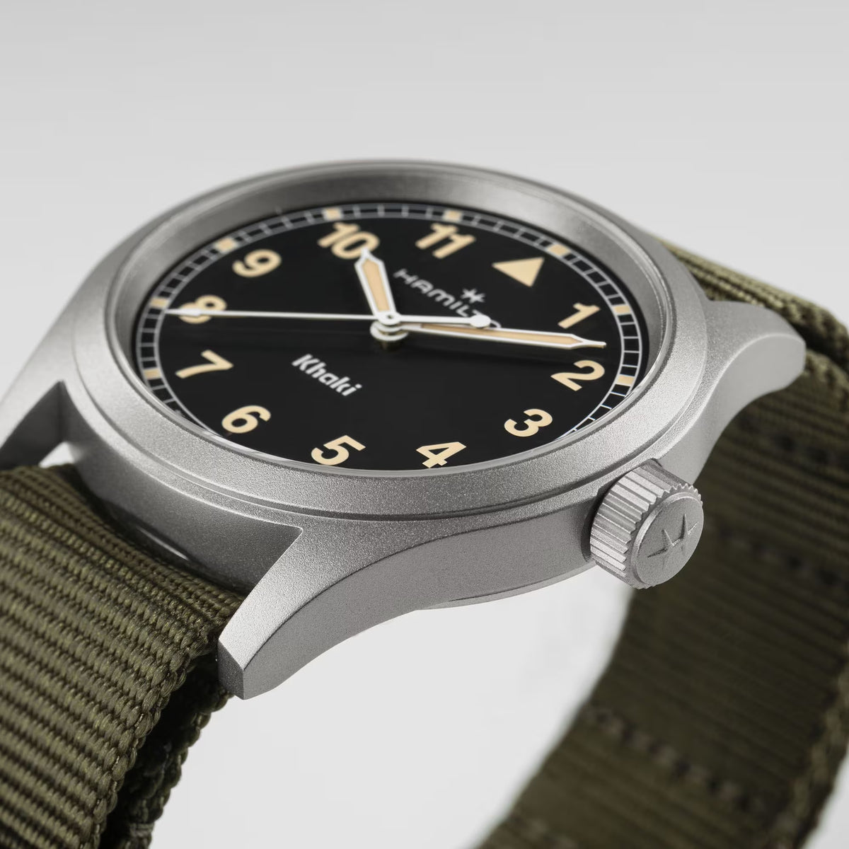 Hamilton Khaki Field H69401930 watch macro view showcasing matte steel bezel, crown detail, and green NATO strap