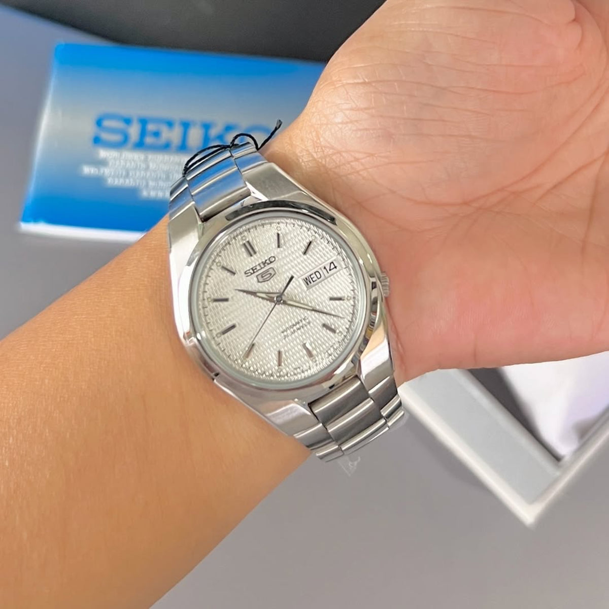Seiko 5 SNK601K1 mens timepiece worn on the wrist, featuring a silver case and day-date window