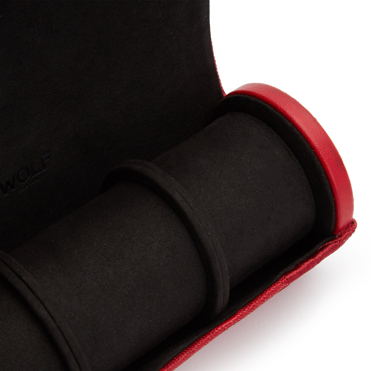 Close-up of black watch cushion inside red watch roll edge and lining.
