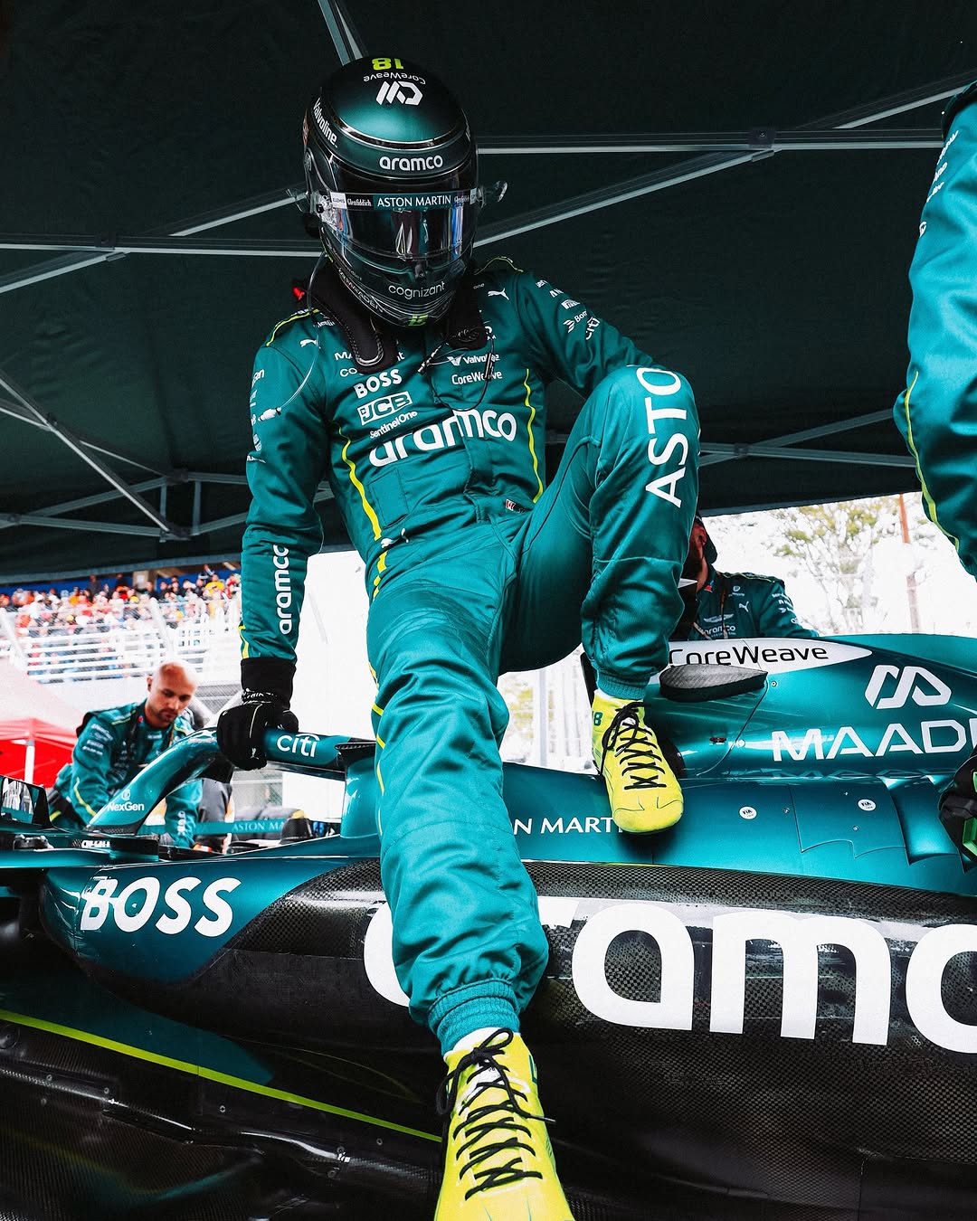 Aston Martin Formula 1 driver stepping out of race car in green suit and yellow boots
