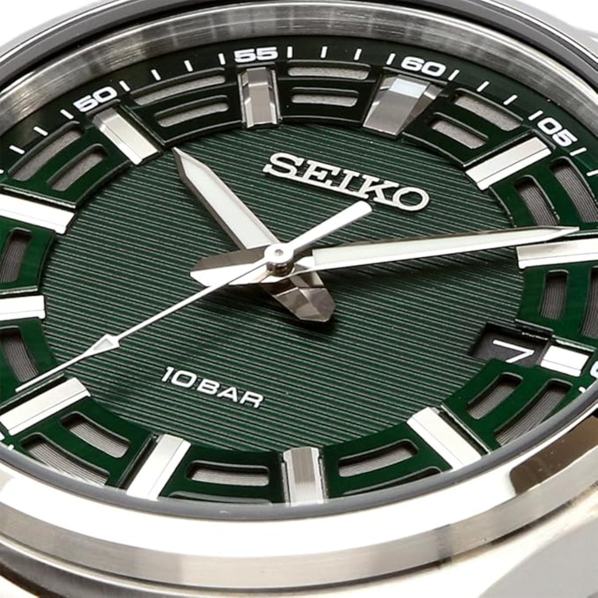 Close-up shot of the patterned green dial, luminous hands, and date window on the Seiko Essentials SUR503P1
