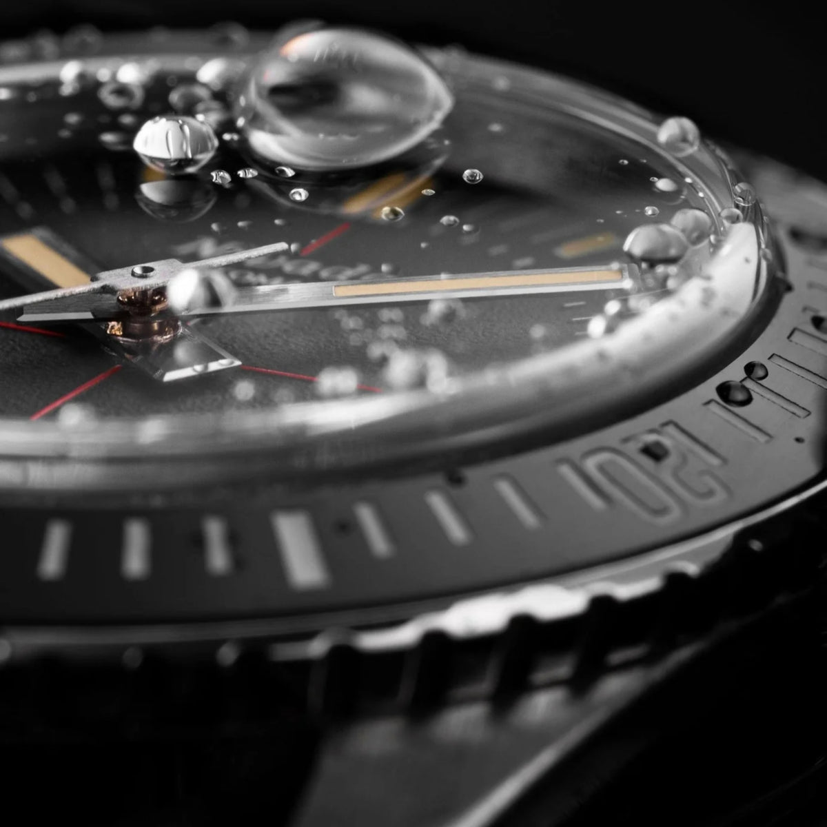 Close-up of black dive bezel and textured case with silver accents and minute markers
