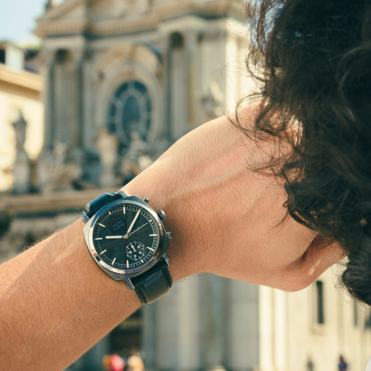 Hybrid smart watch on wrist, dark slate dial with black leather strap