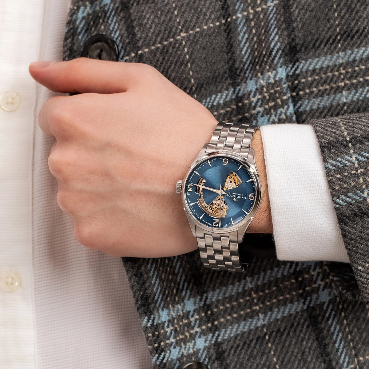 Men's automatic watch with blue open-heart dial on stainless steel bracelet, worn