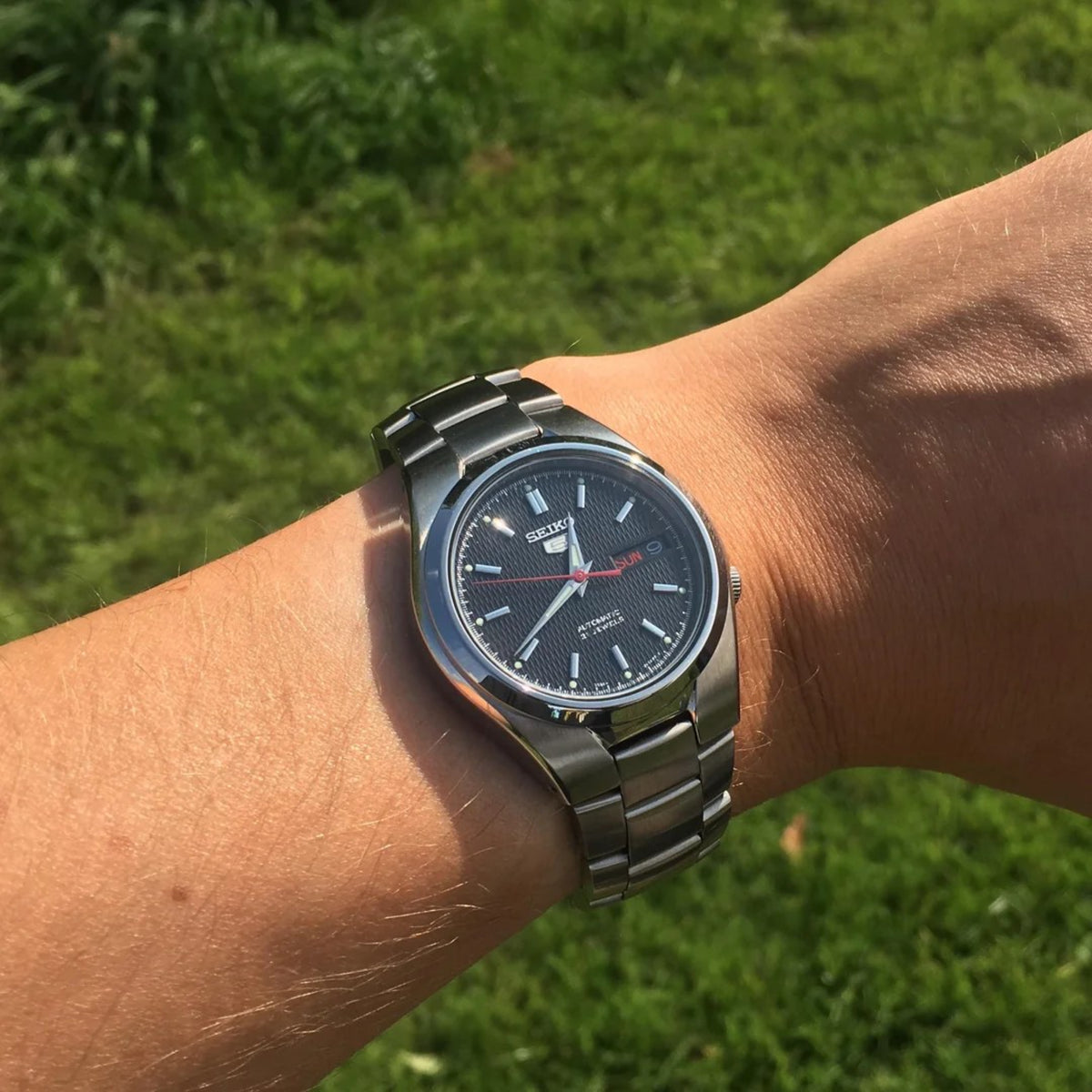 Seiko 5 Classic SNK607K1 wrist shot showcasing black dial with steel watch bracelet