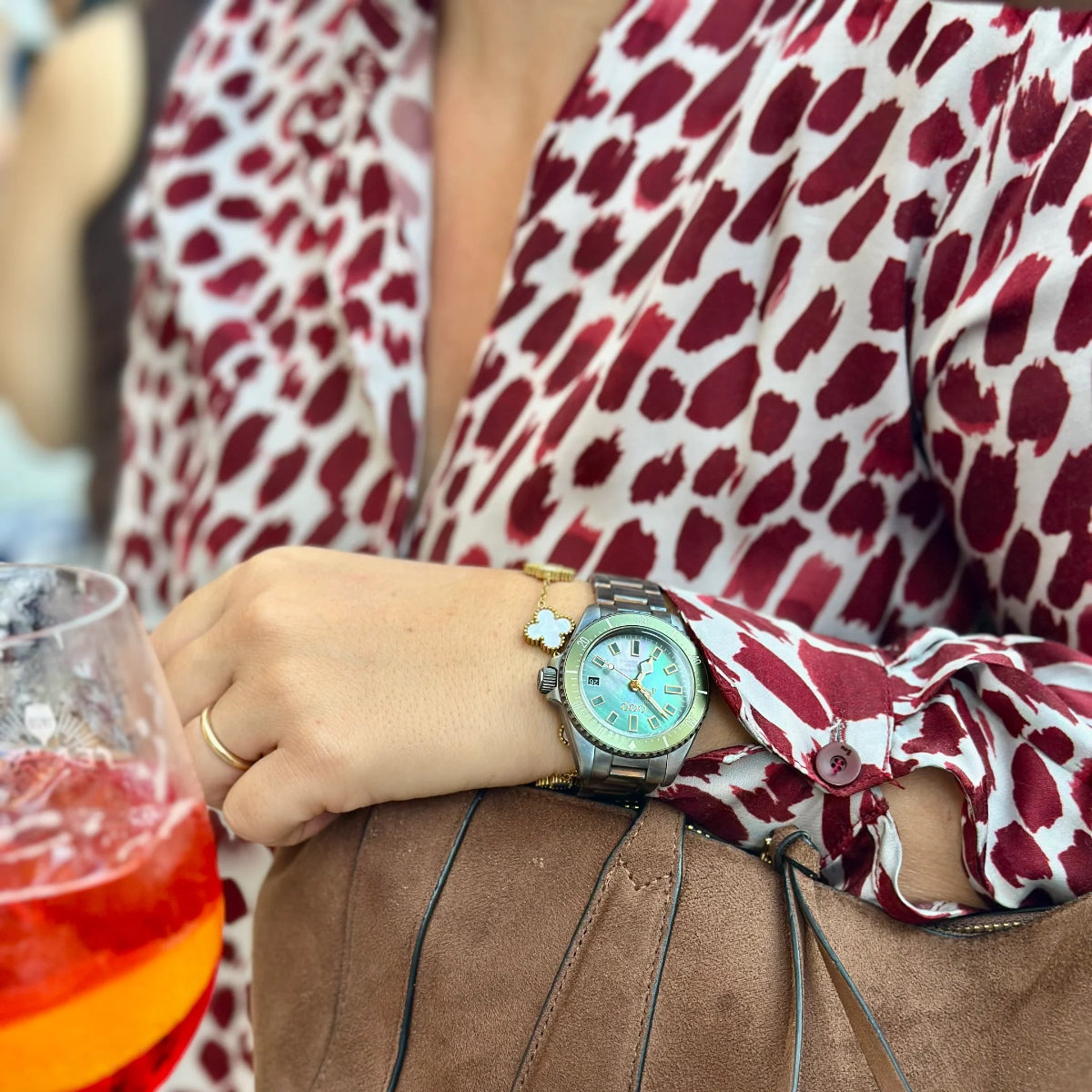 Light blue dial watch with gold hands and markers on brown wrist strap