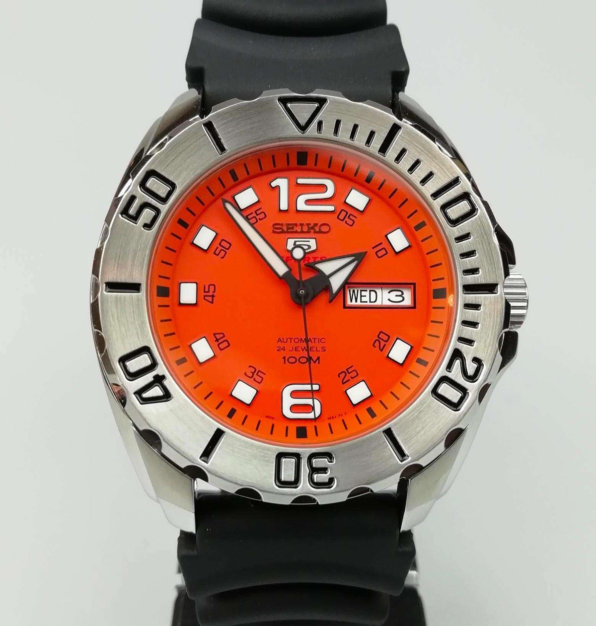 Orange dial automatic sports watch on black rubber strap with day-date display