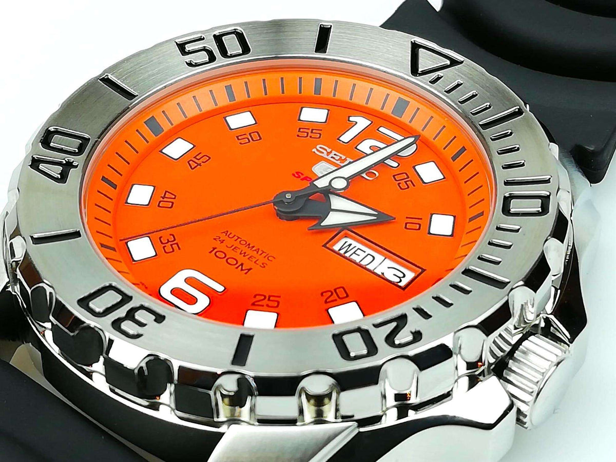 Orange dial Seiko sports watch on black strap with steel bezel and date display