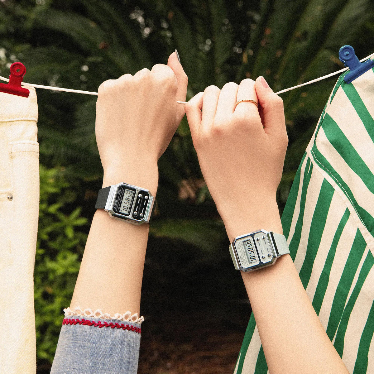 Two Casio digital watches on wrists with resin straps, rectangular LCD displays