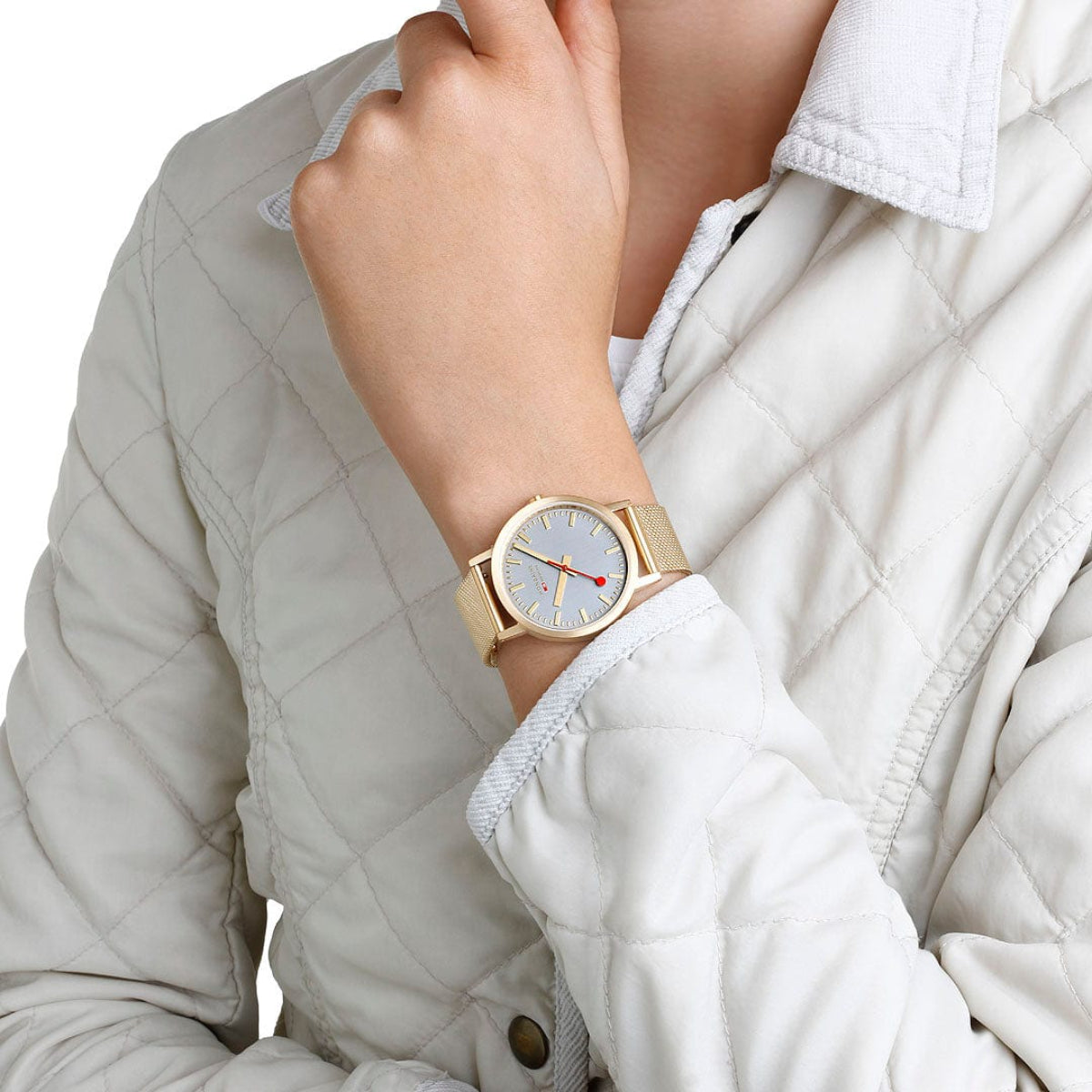 Quartz watch on wrist with gold-tone mesh strap and gray dial