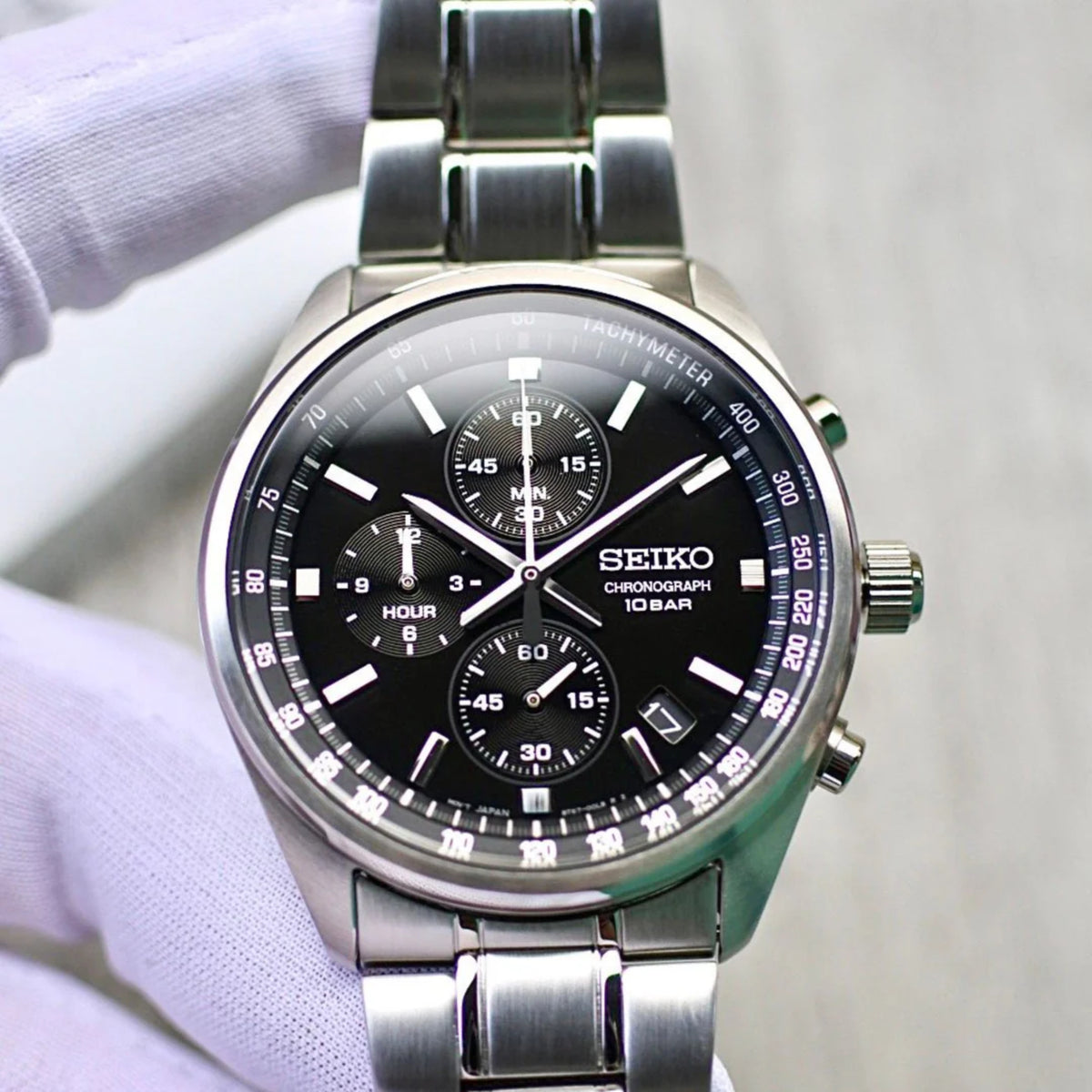 Seiko Essentials SSB379P watch with black dial and silver metal band on a white background
