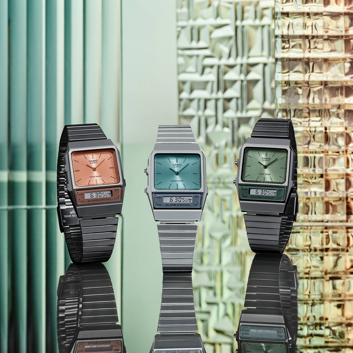 Orange dial quartz watch with black case and black link strap, shown with others