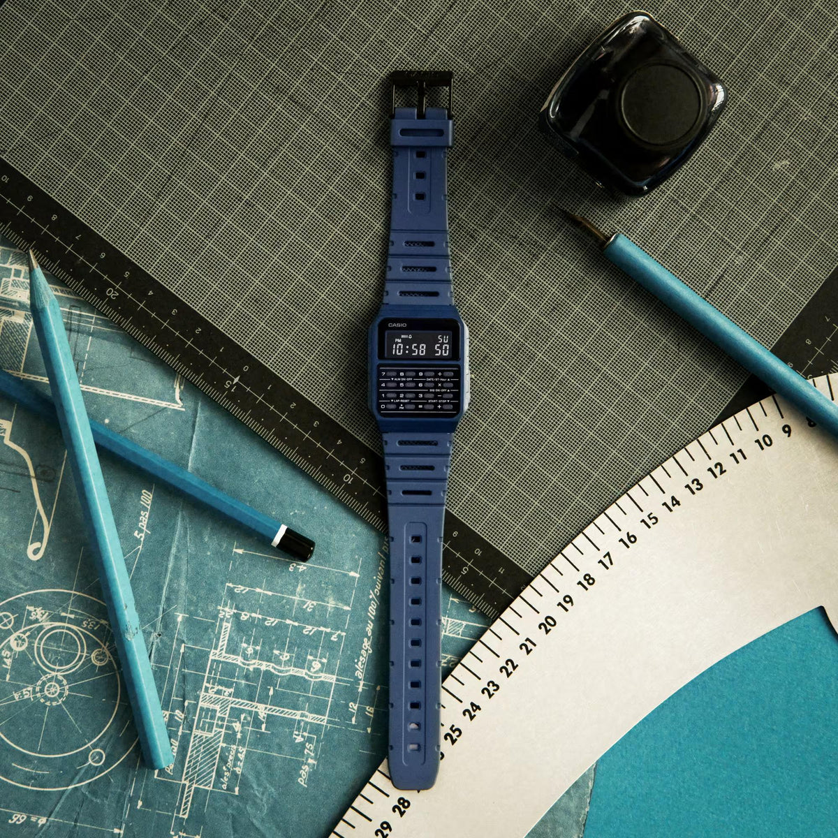 Blue resin strap digital watch with black face, worn over flat tools