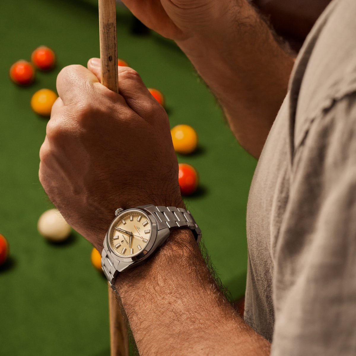 Men's steel bracelet watch on wrist, champagne dial with baton hour markers