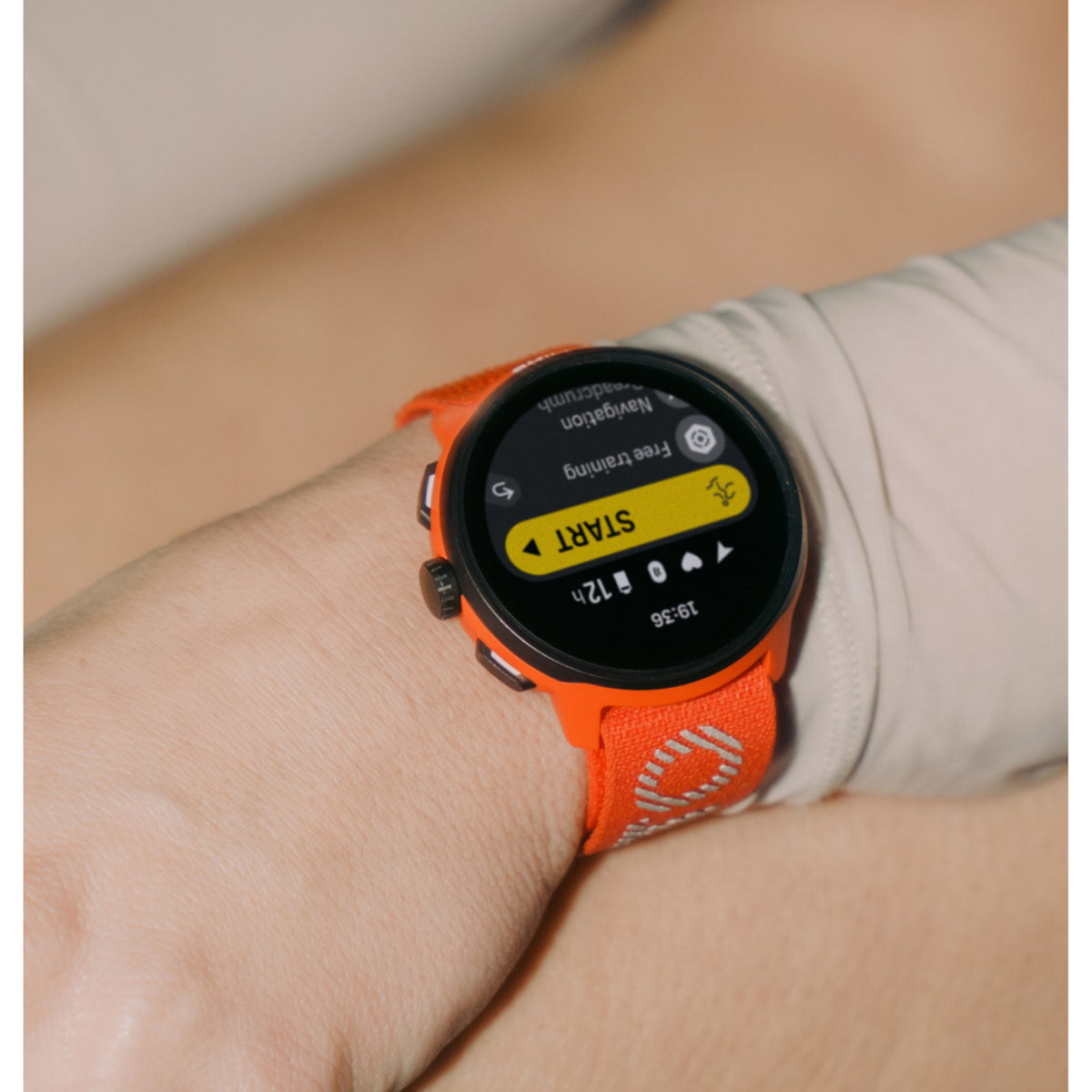 Suunto multisport smartwatch featuring a digital activity interface and red-orange woven nylon band