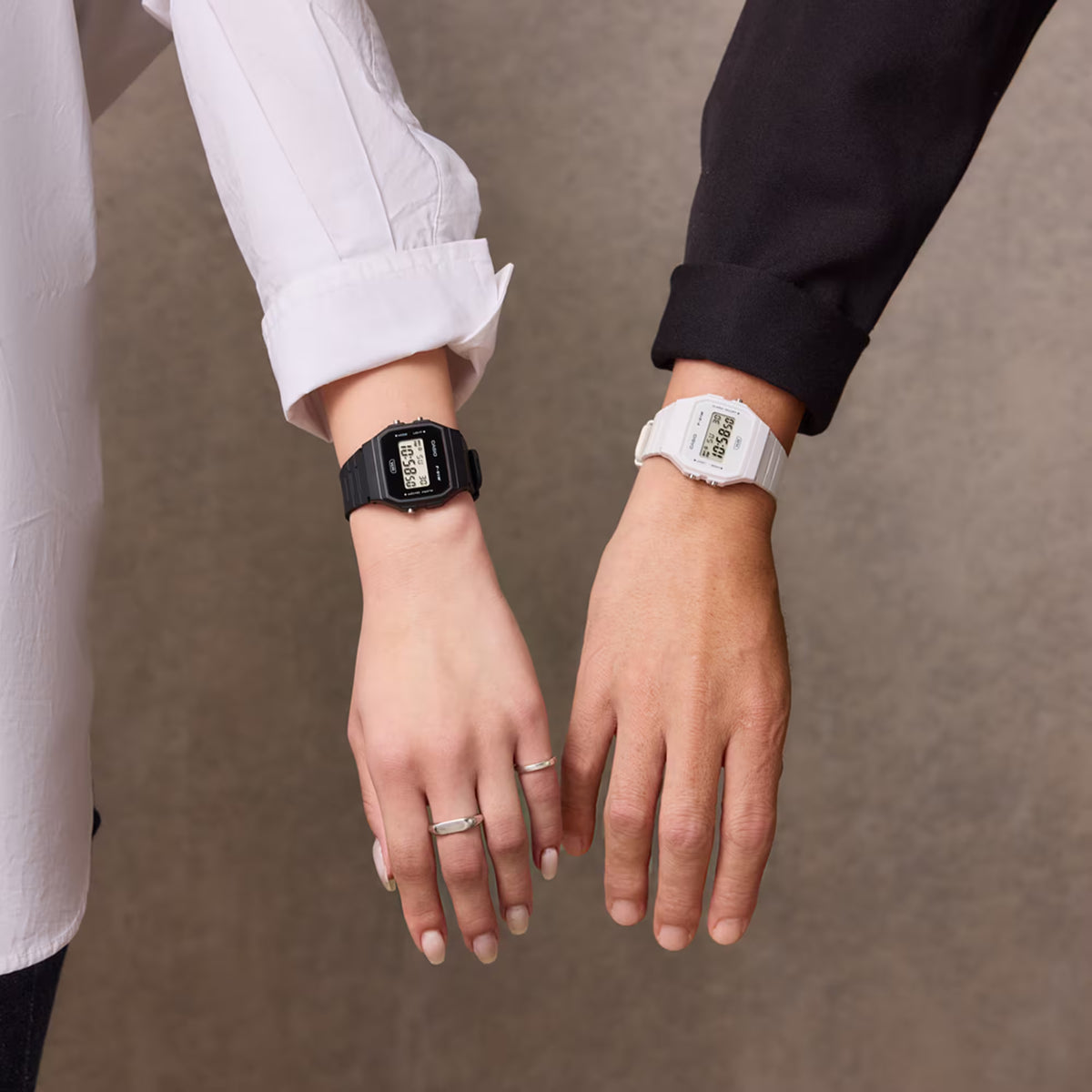 Black digital resin strap watch worn on wrist with glowing LCD time