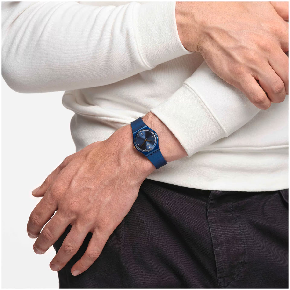 Blue quartz watch on wrist; round blue dial with gold hands and markers, silicone band