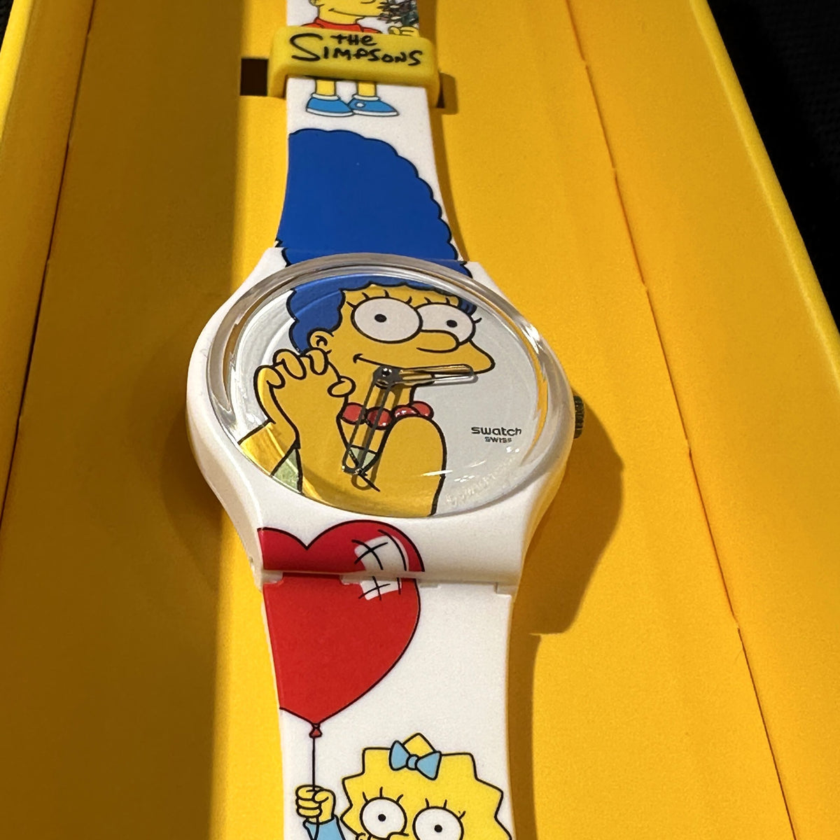 Swatch ladies watch with round Homer face and white strap showing red heart and character art