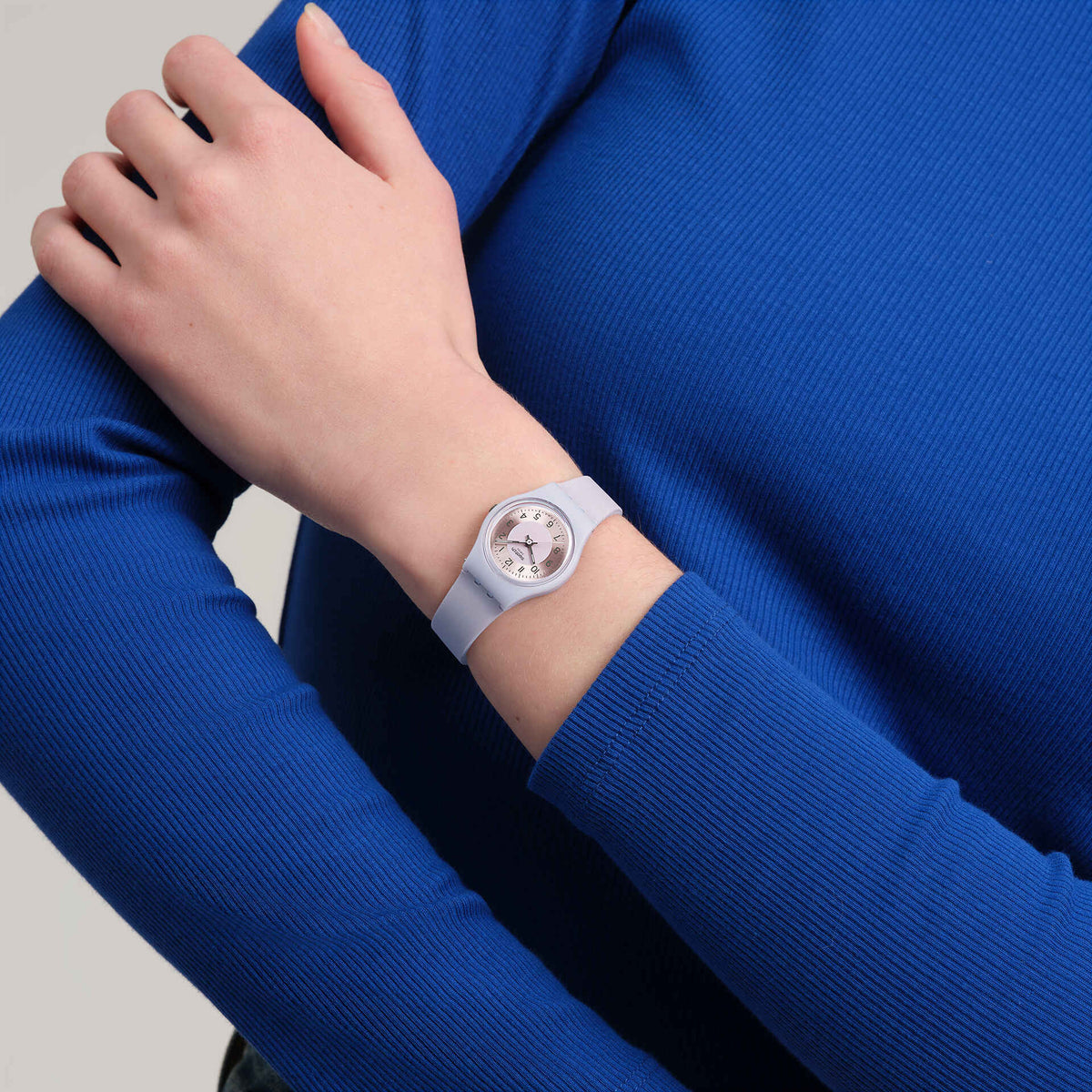 Lilac silicone strap watch on wrist, round dial with numerals and hands