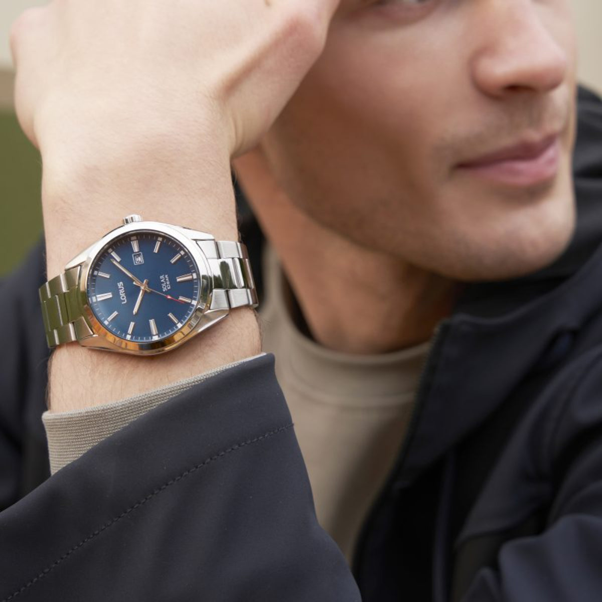 Lorus solar men's wristwatch worn on wrist with silver-tone metal bracelet and blue dial