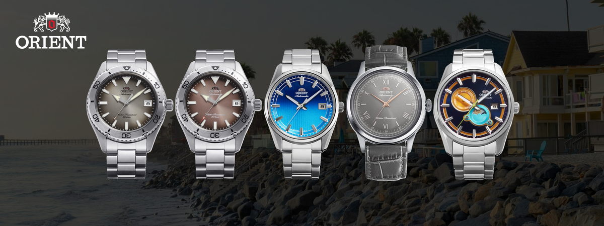 Five Orient watches displayed against a dark background with a house and palm trees