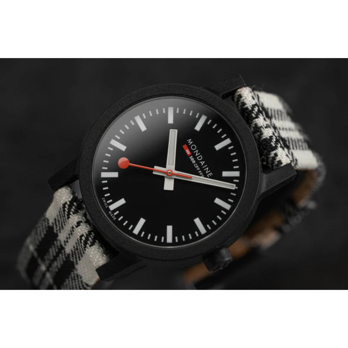 Ladies quartz wristwatch with black dial and red accent hands on black-and-white tartan strap