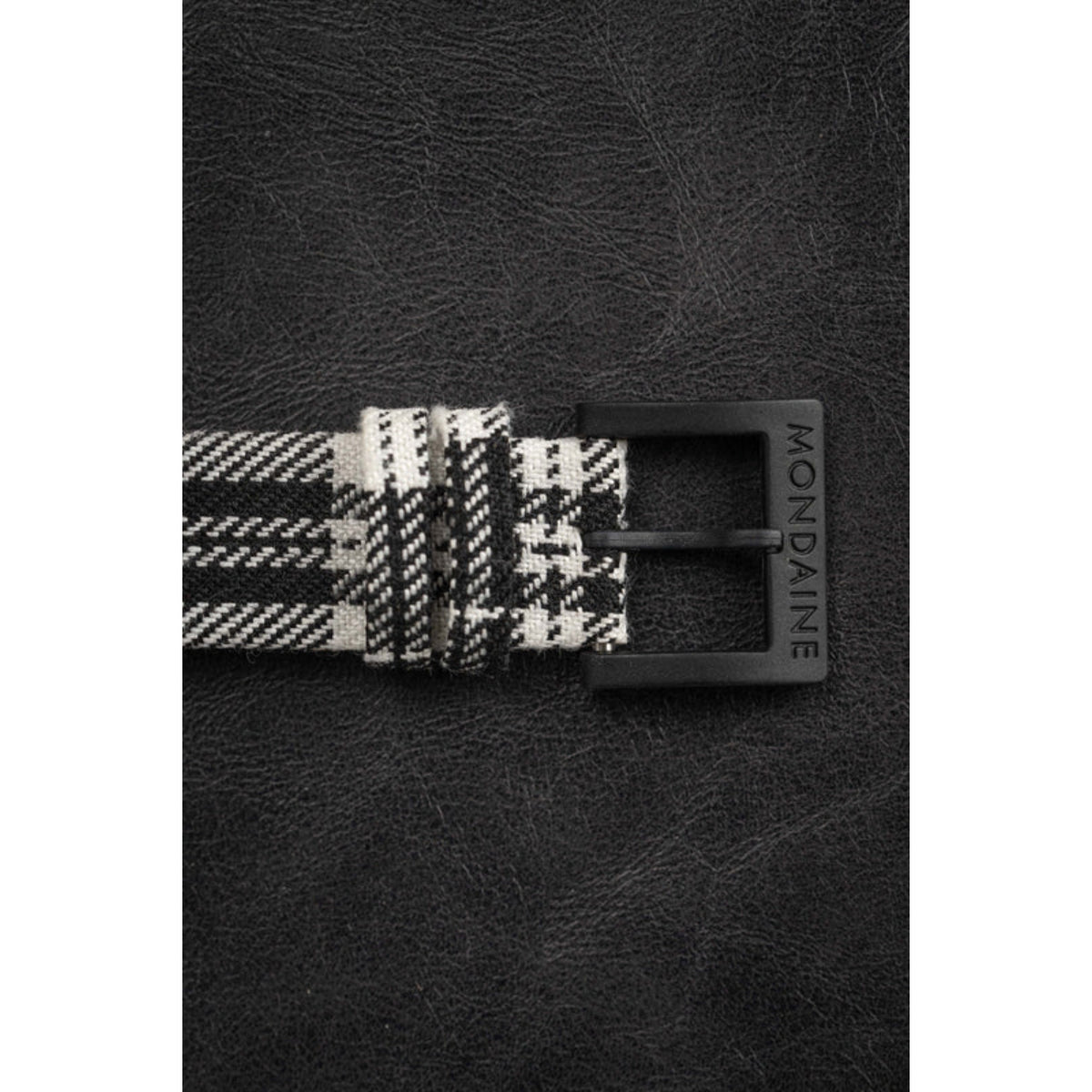 Black buckle and strap end detail on black-and-white tartan synthetic strap with MONDAINE branding
